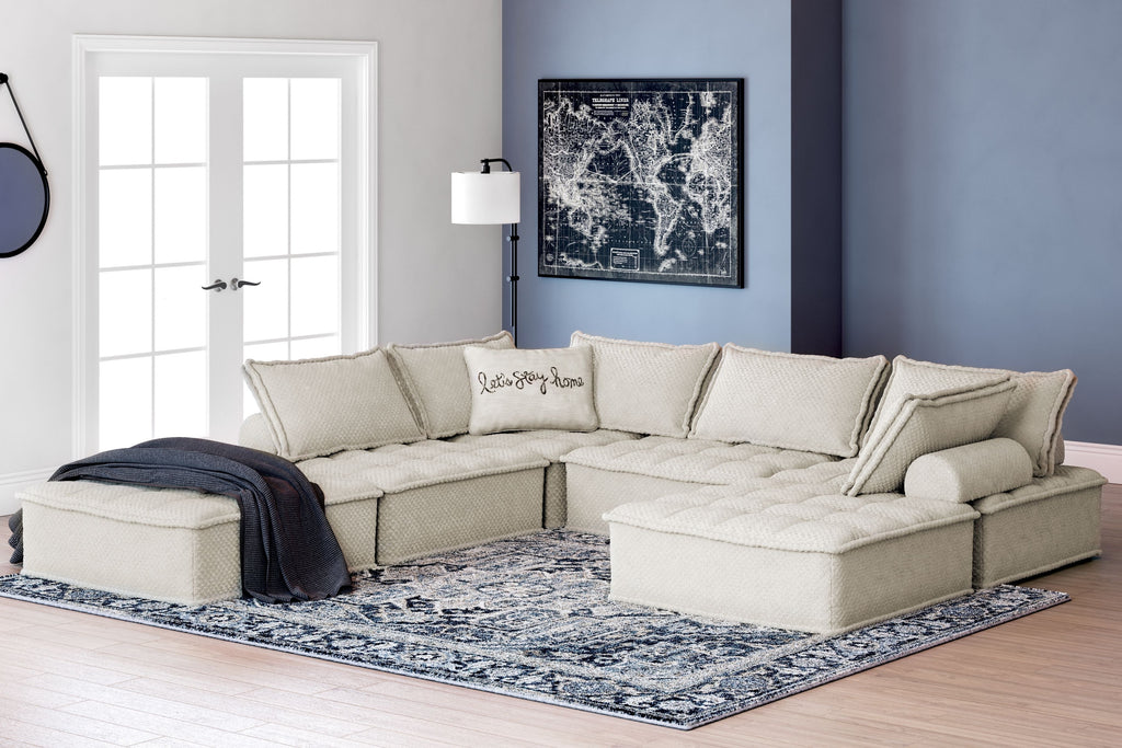 Taupe modular sectional with multiple seats and back pillows, styled with a chaise section