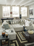 Taupe modular sectional sofa with chaise seating and assorted patterned accent pillows