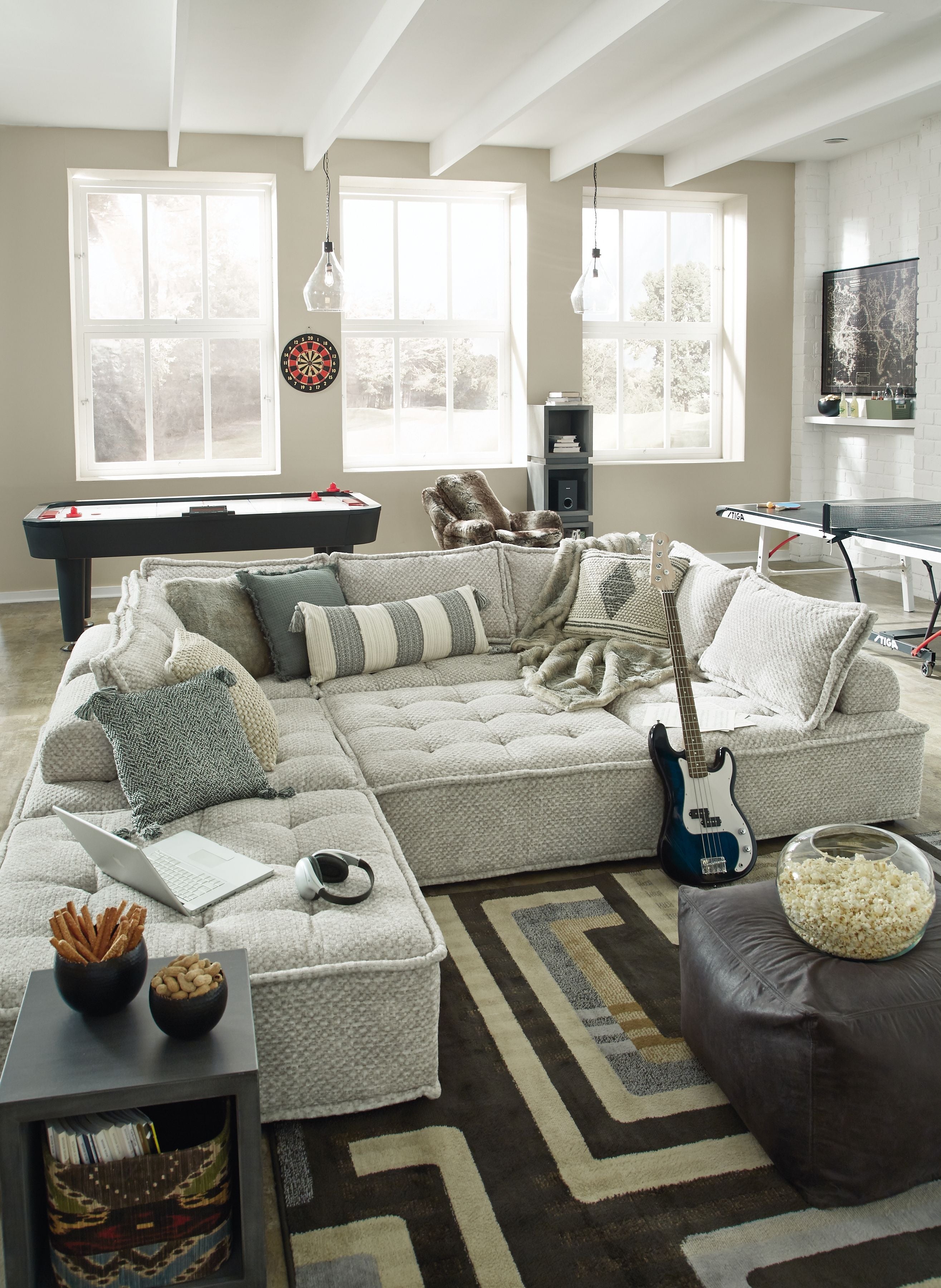 Taupe modular sectional sofa with chaise seating and assorted patterned accent pillows