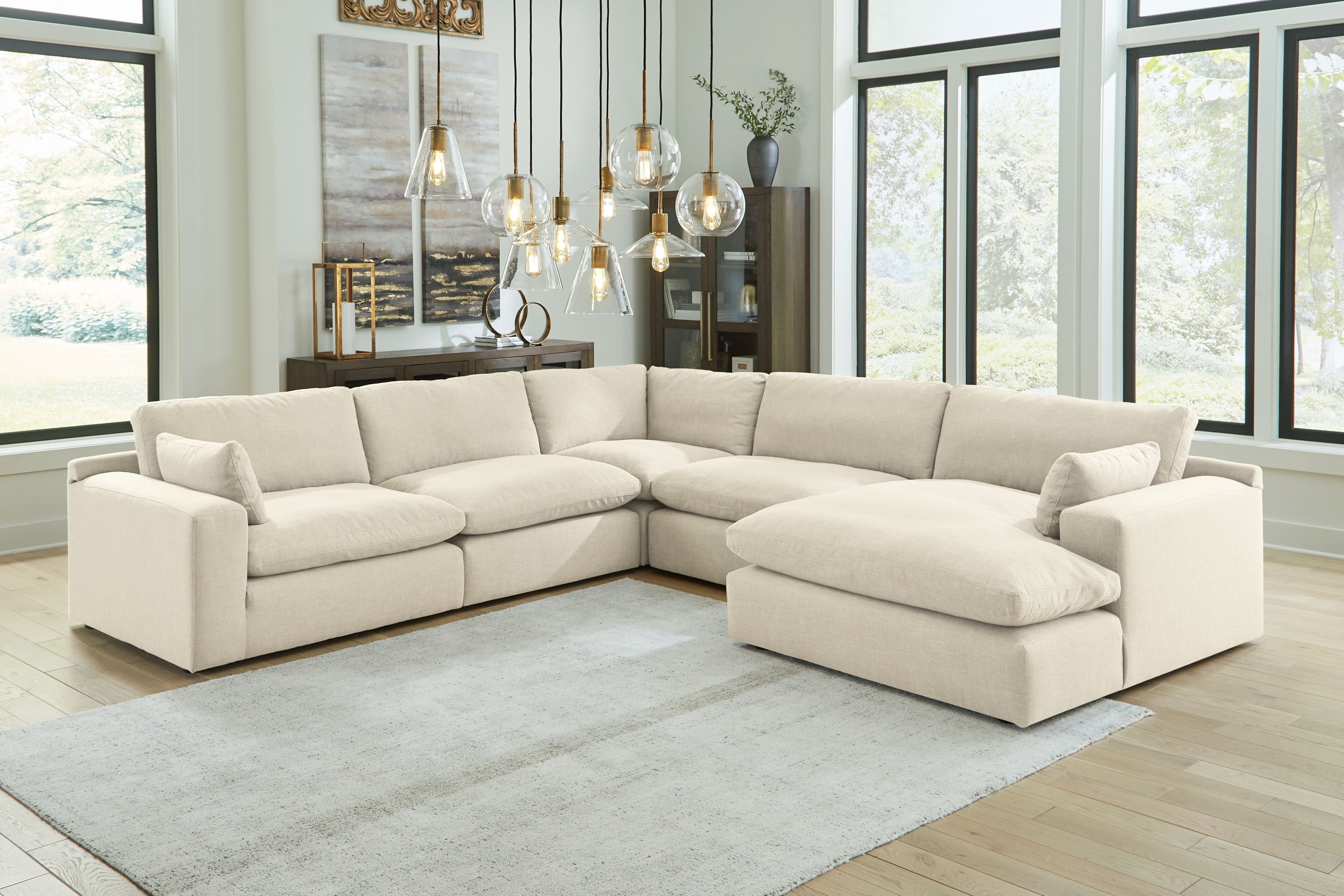 Beige linen sectional sofa with chaise, low back pillows and extended ottoman seat