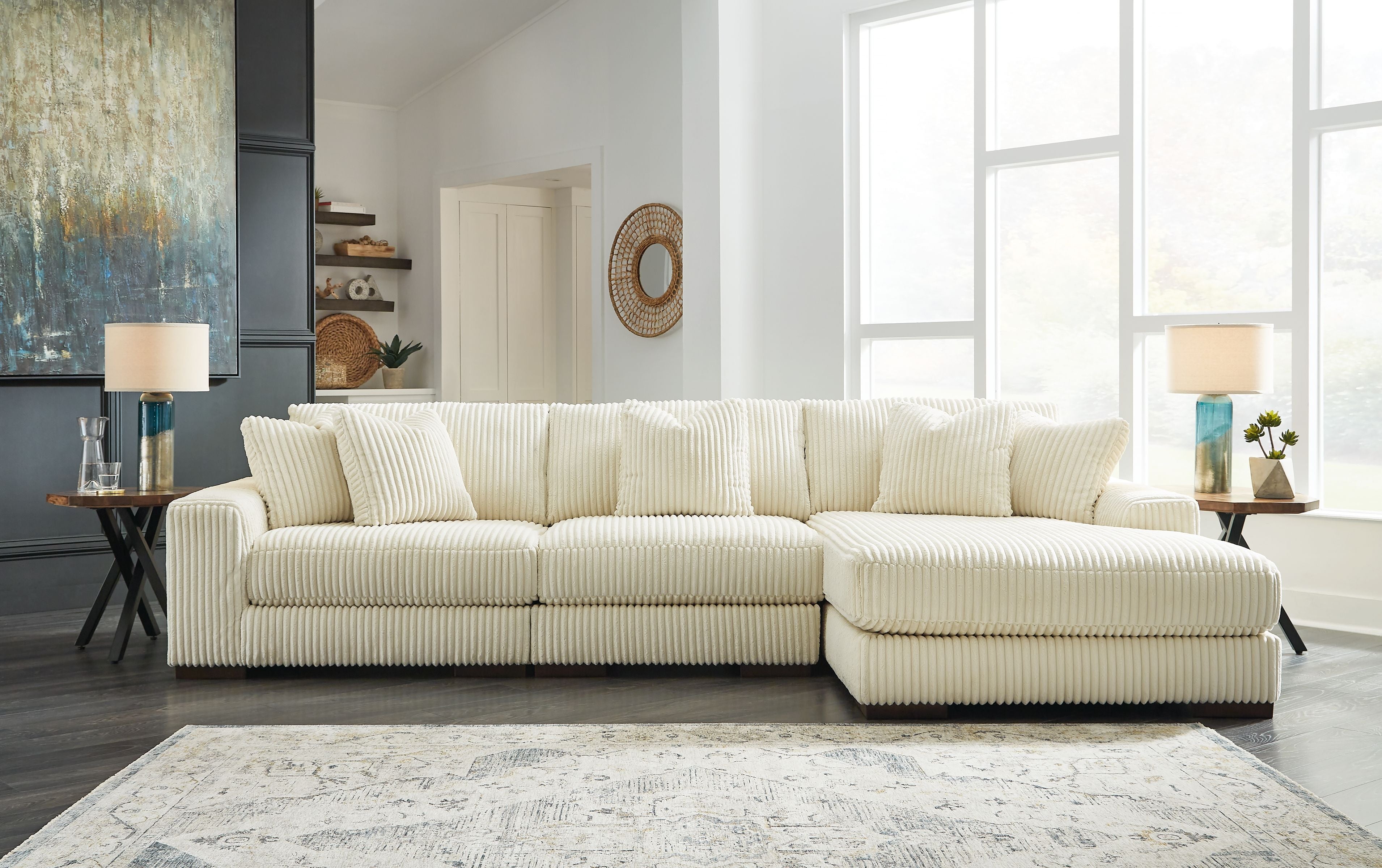 Ivory sectional sofa with chaise and tufted back cushions, in ribbed textured fabric.