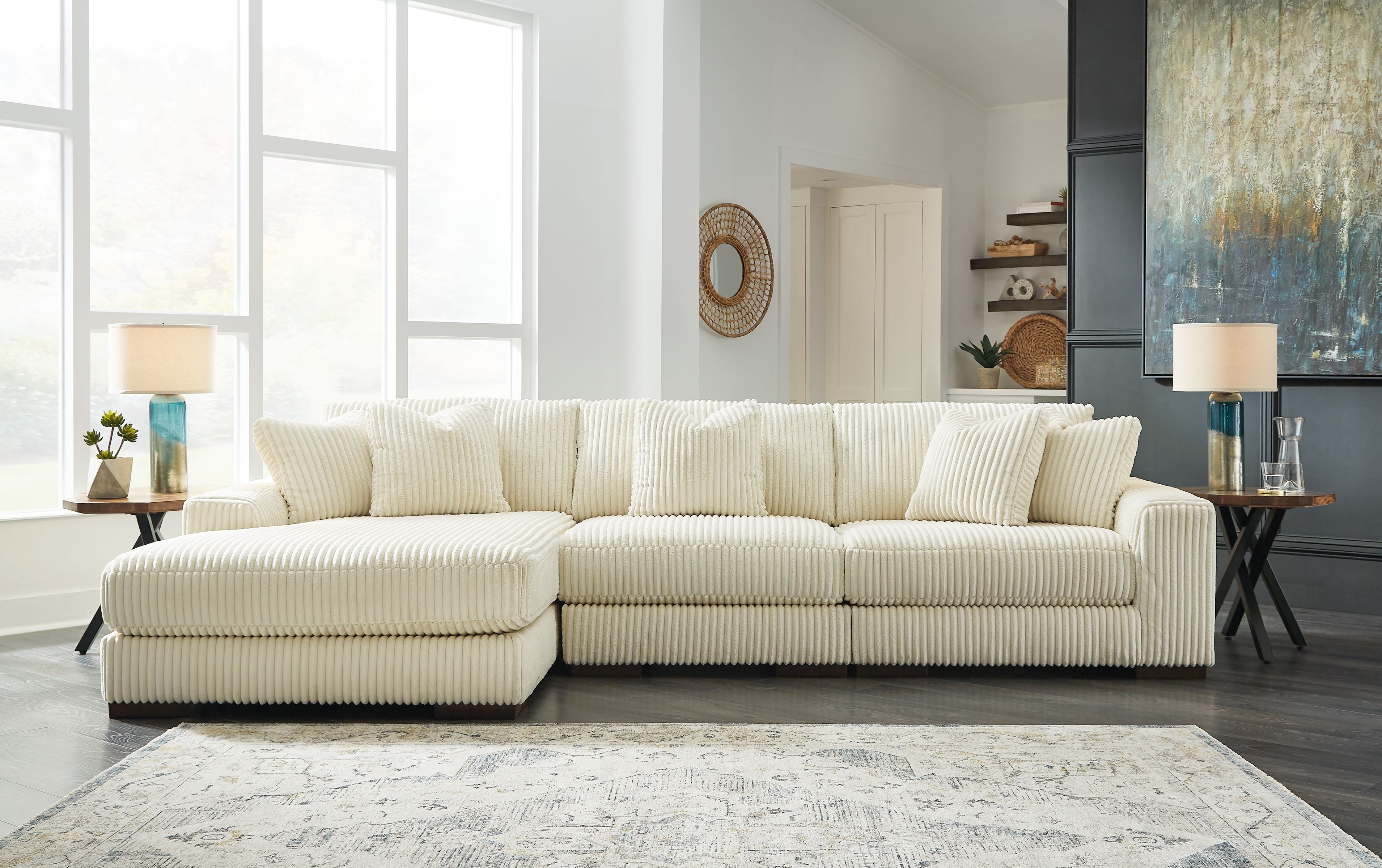 Ivory sectional sofa with chaise and multiple back cushions, ribbed textured upholstery.