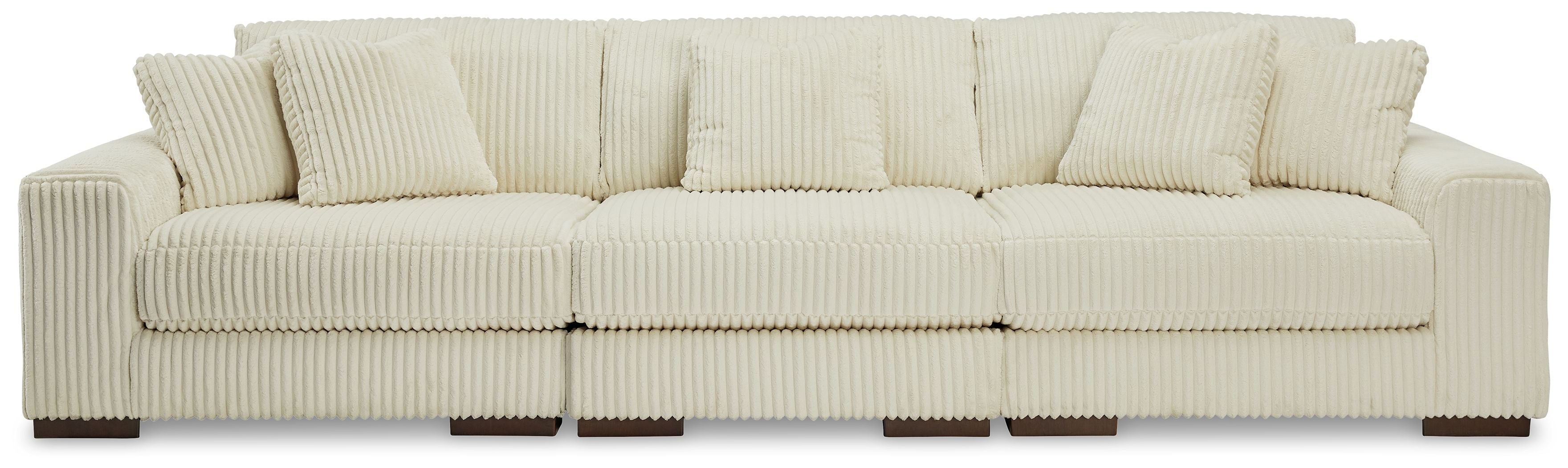 Ivory sectional sofa with three back cushions, track arms, and ribbed upholstery.