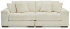 Ivory sectional sofa with plush tufted back cushions and ribbed channel texture.