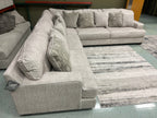 Beige sectional sofa with reversible chaise end and multiple back pillows