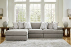 Light gray sectional sofa with corner chaise and multiple patterned throw pillows.