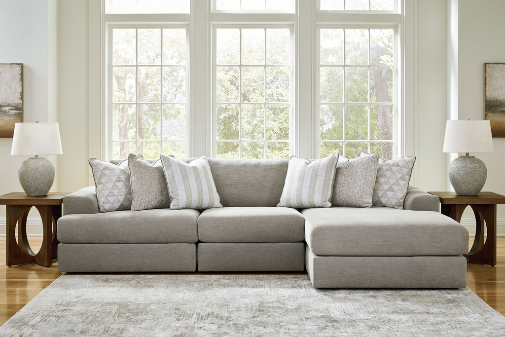 Light gray sectional sofa with ottoman-style chaise and decorative throw pillows.