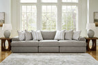 Light gray sectional sofa with chaise section and assorted striped and textured throw pillows.