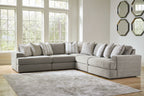 Light gray sectional sofa with chaise arm and multiple throw pillows in neutral tones.
