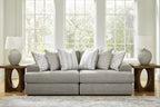Light gray sectional sofa with two-seat center and multiple patterned throw pillows.