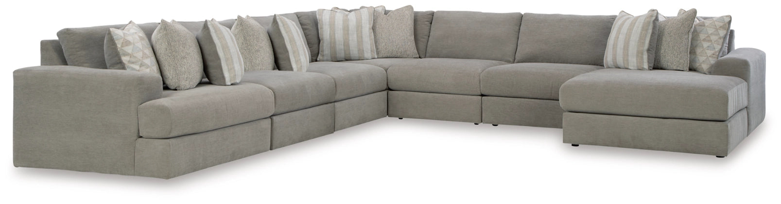 Gray L-shaped sectional sofa with chaise-style ottoman and stacked accent pillows.