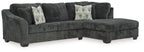 Dark charcoal corner chaise sectional sofa with tufted seat cushions and accent pillows