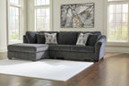 Dark gray corner sectional with chaise, tufted arms, and patterned accent pillows
