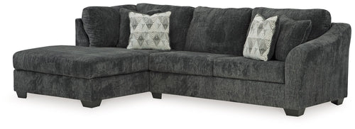 Dark charcoal sectional sofa with chaise, tufted cushions and patterned accent pillows
