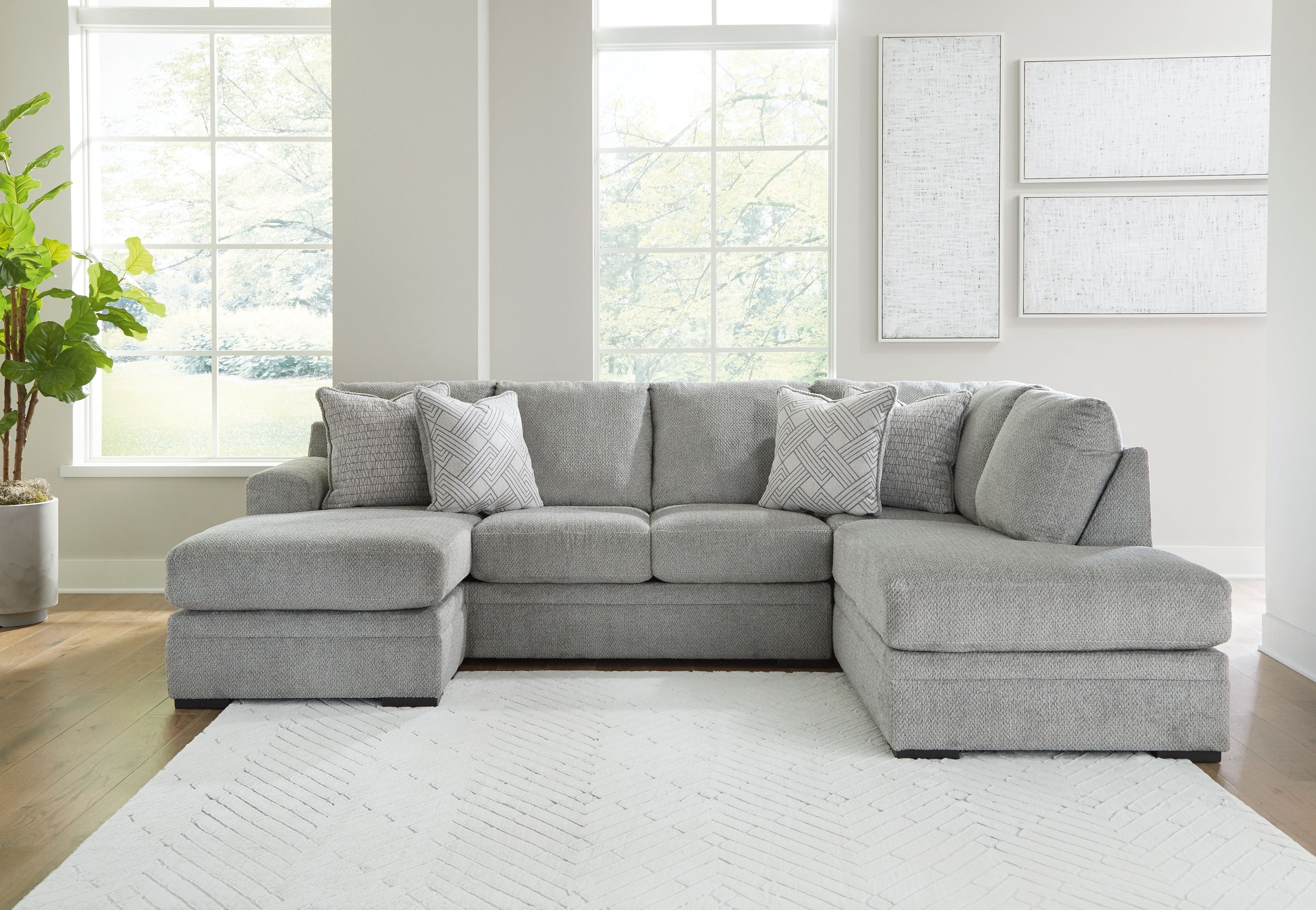 Grey corner chaise sectional sofa with chaise ottoman and patterned accent cushions.
