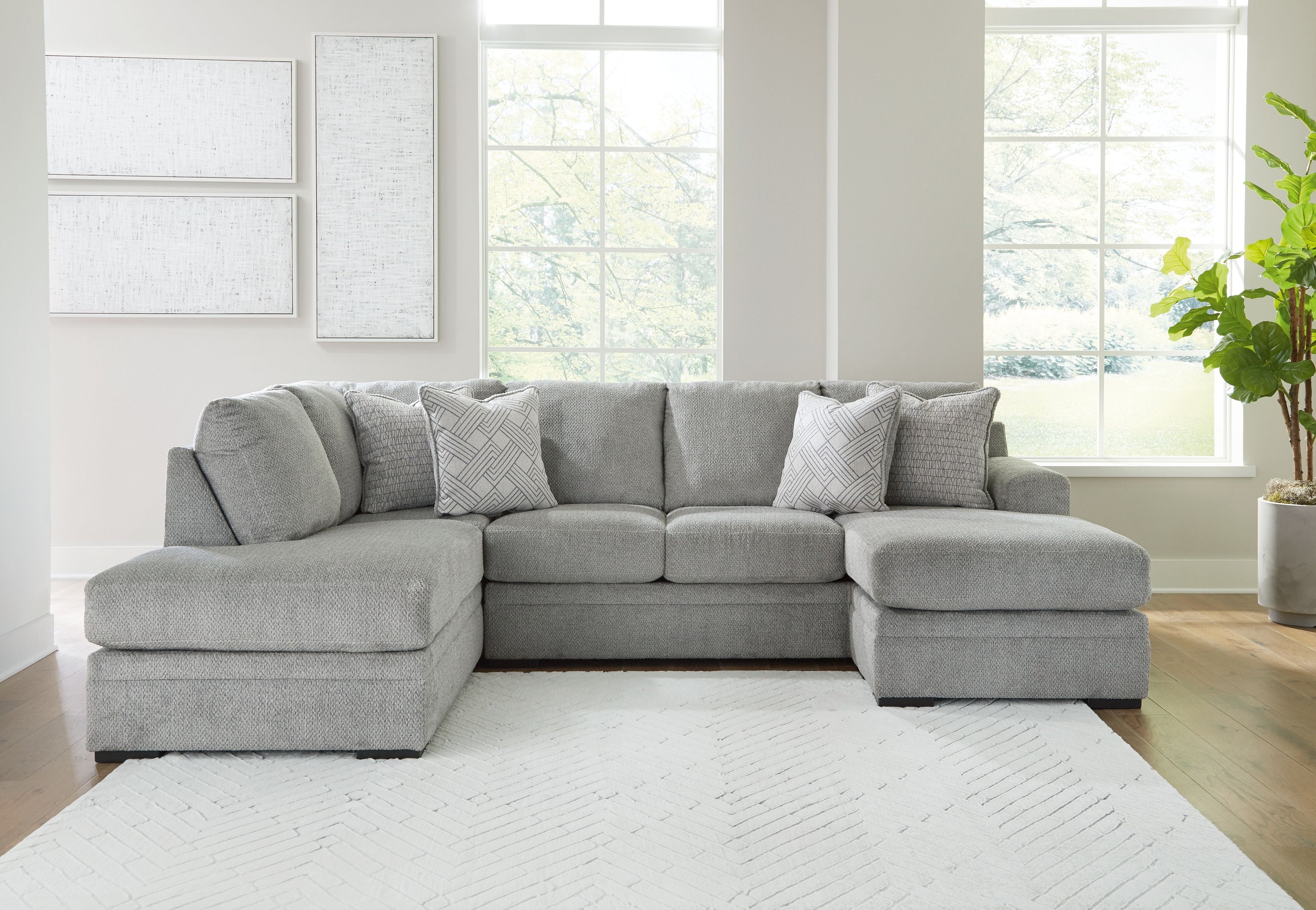 Grey sectional sofa with corner chaise and four patterned accent pillows.