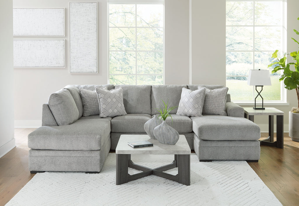 Grey sectional sofa with corner chaise and multiple patterned accent cushions.