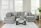 Grey sectional sofa with corner chaise and multiple patterned accent cushions.