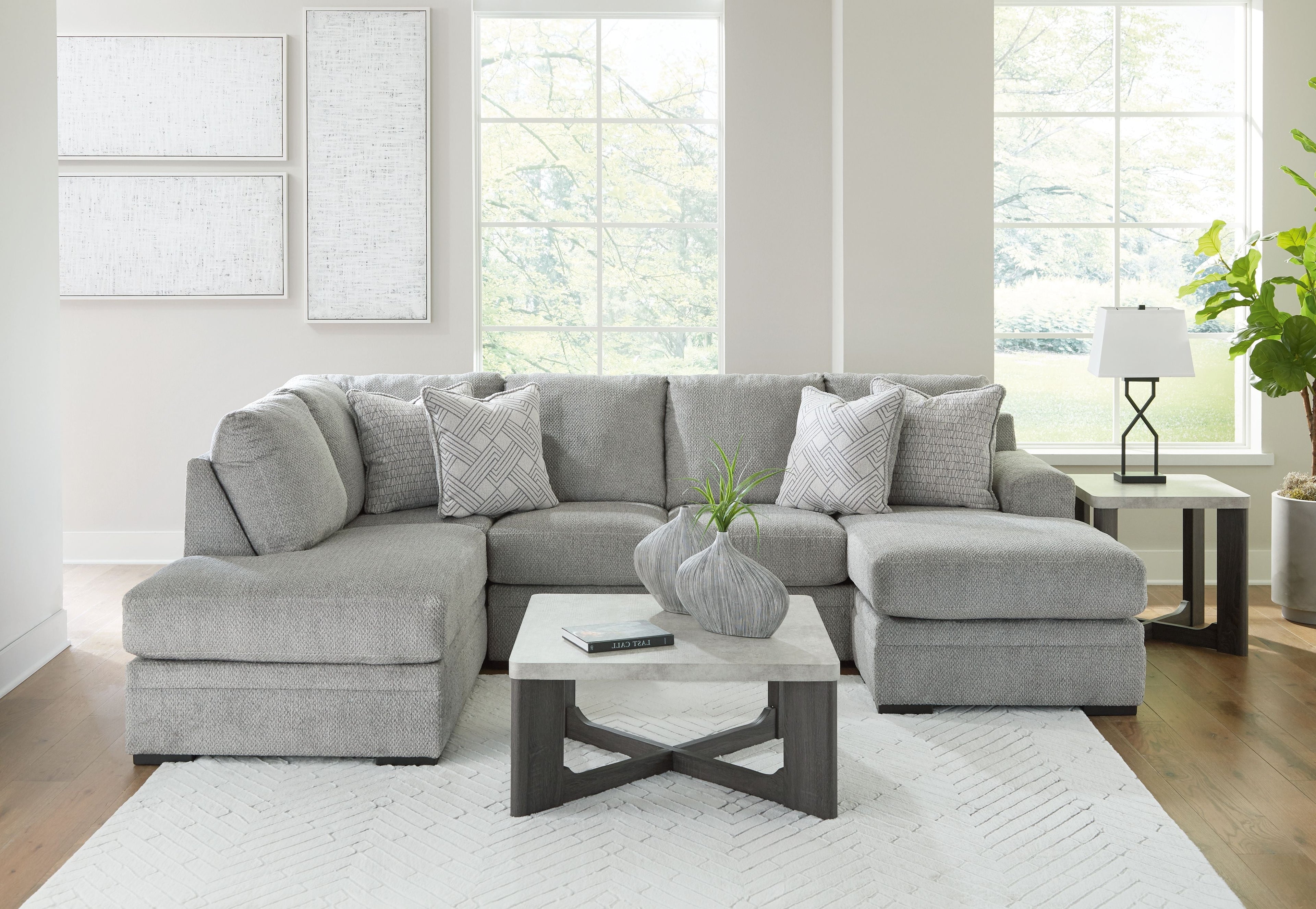 Grey sectional sofa with corner chaise and multiple patterned accent cushions.