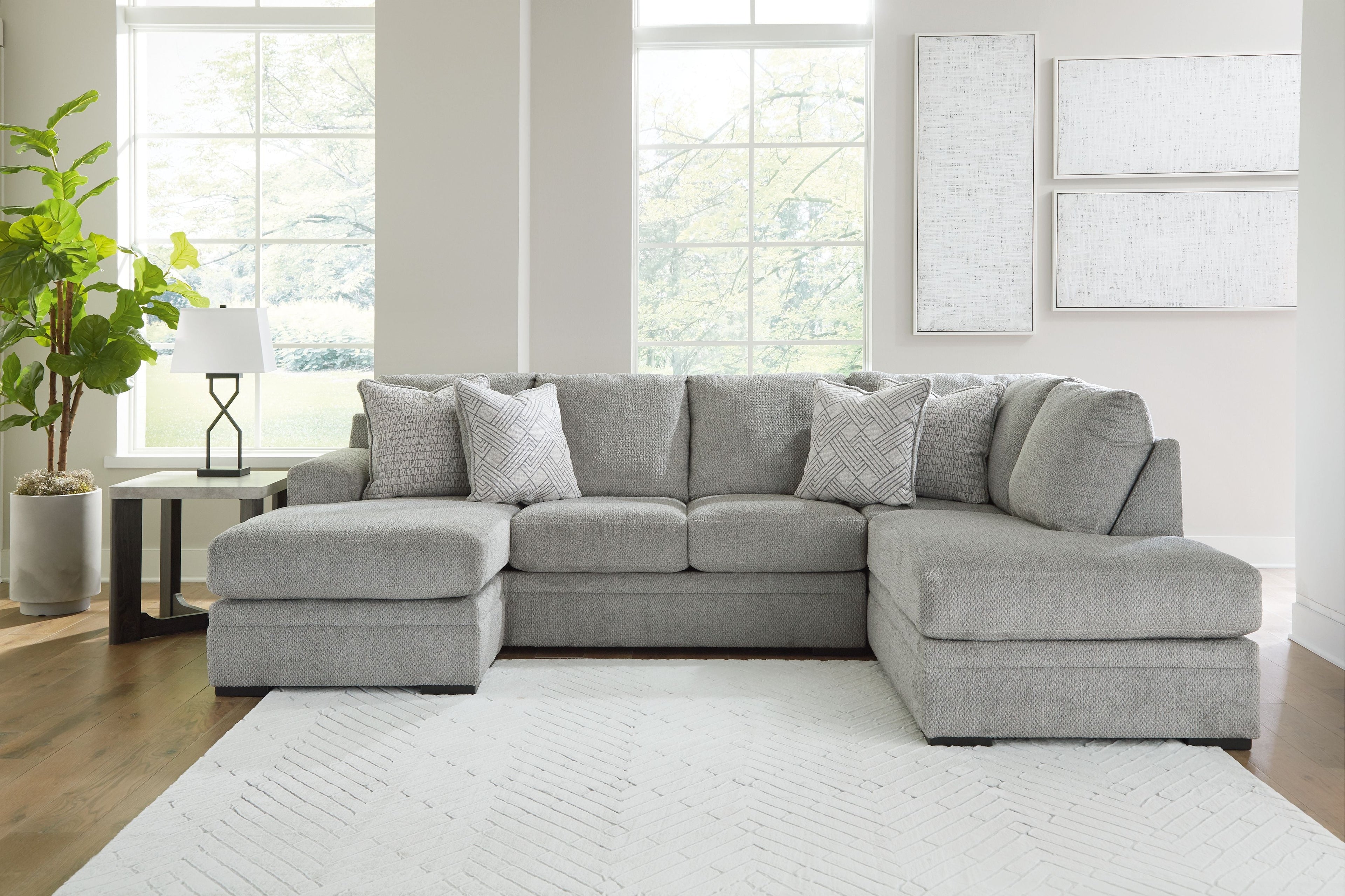 Grey corner chaise sectional sofa with patterned throw pillows and arm cushions.