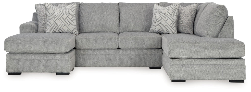 Grey sectional sofa with corner chaise and two patterned accent pillows.
