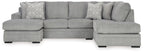 Grey sectional sofa with corner chaise and two patterned accent pillows.