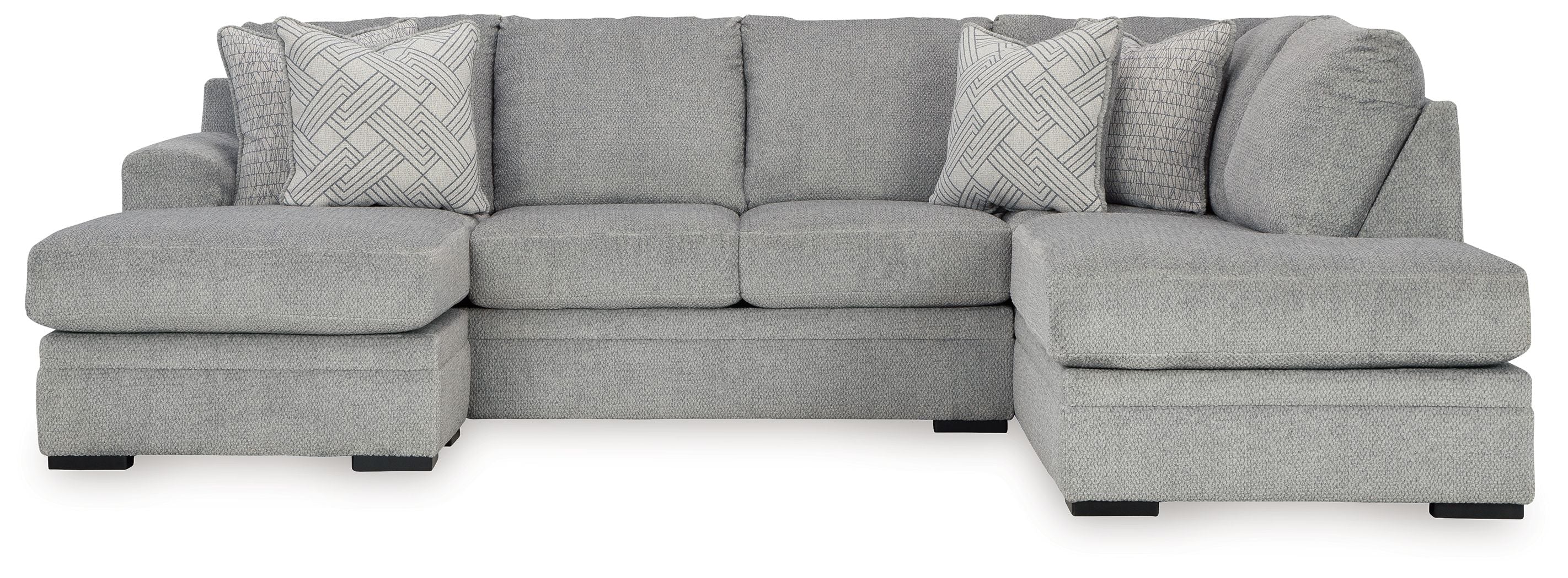Grey sectional sofa with corner chaise and two patterned accent pillows.