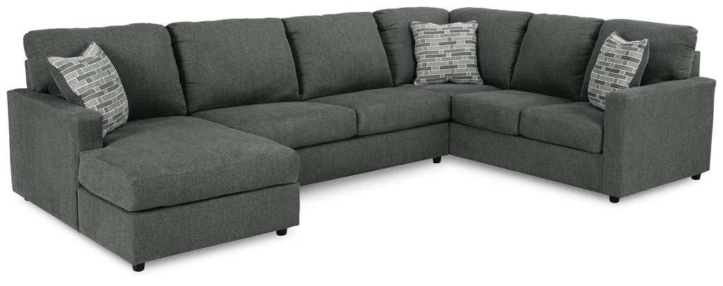 Charcoal sectional sofa with chaise, tufted cushions, and two decorative throw pillows