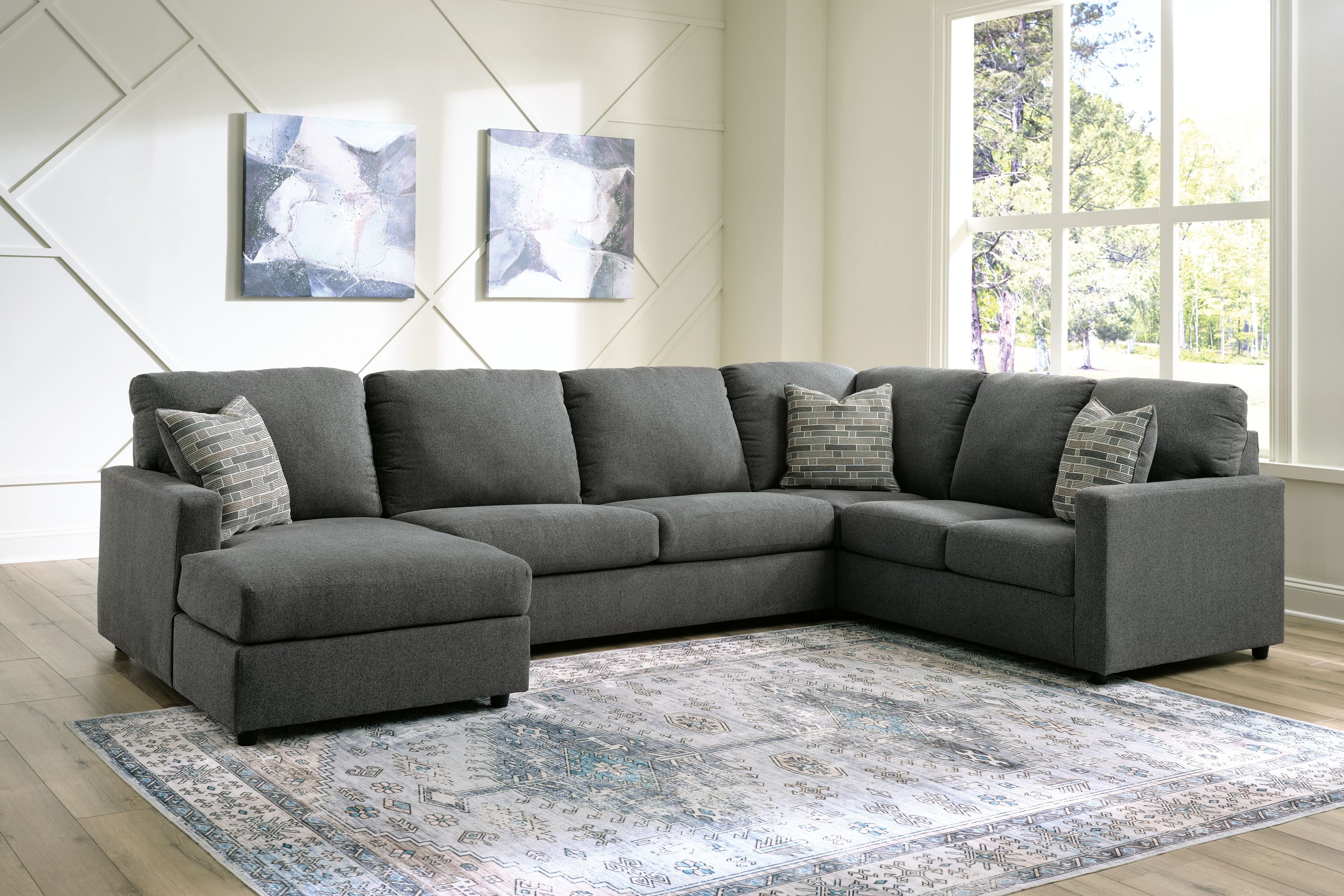 Charcoal sectional sofa with chaise, back cushions, and two patterned accent pillows