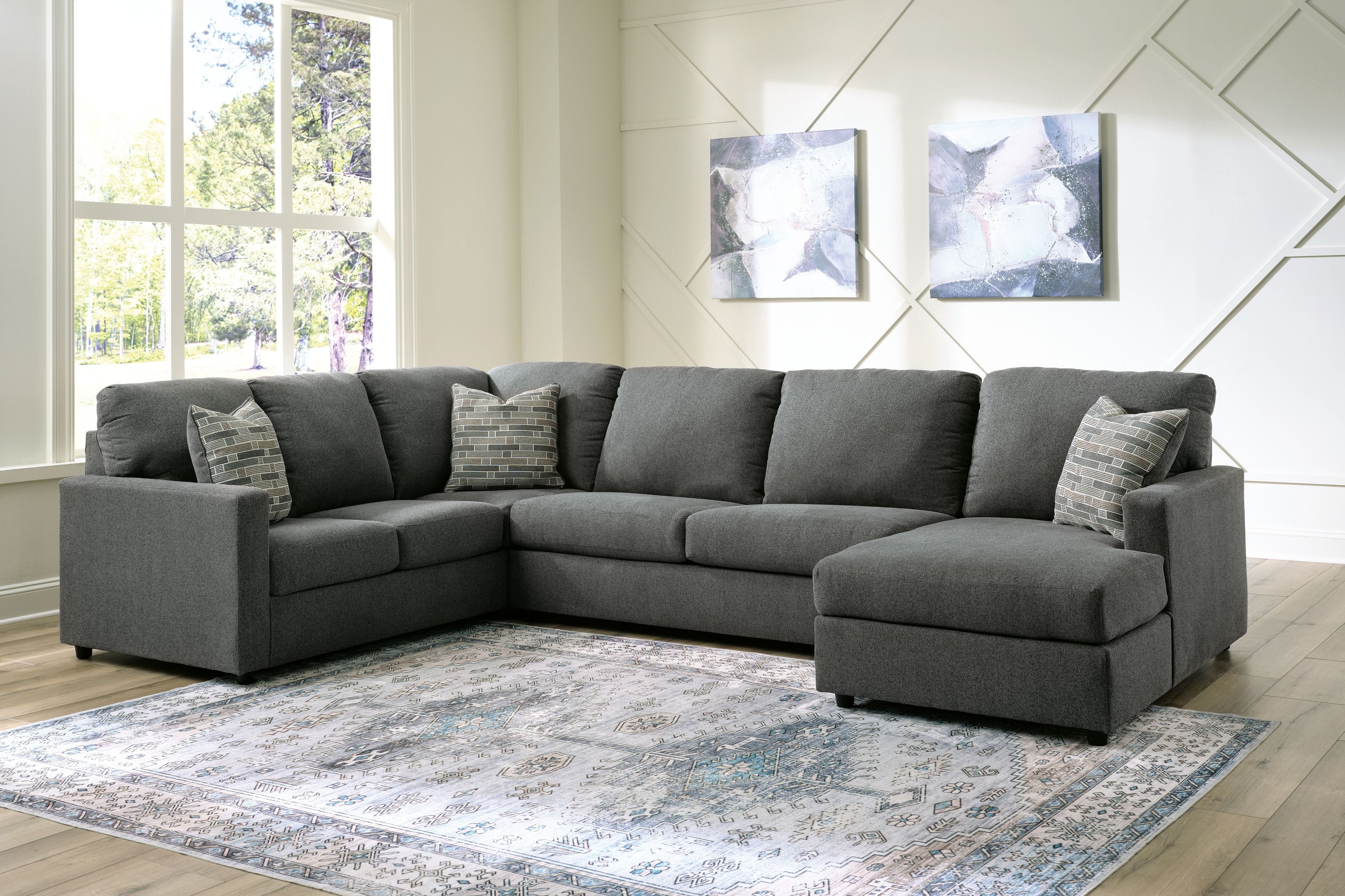 Charcoal sectional sofa with chaise and multiple back cushions, shown with throw pillows