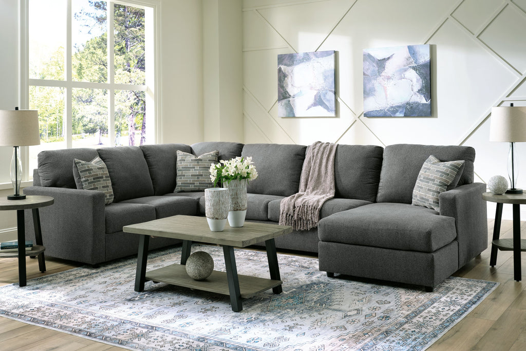 Charcoal sectional sofa with chaise, cushioned arms, and two patterned throw pillows
