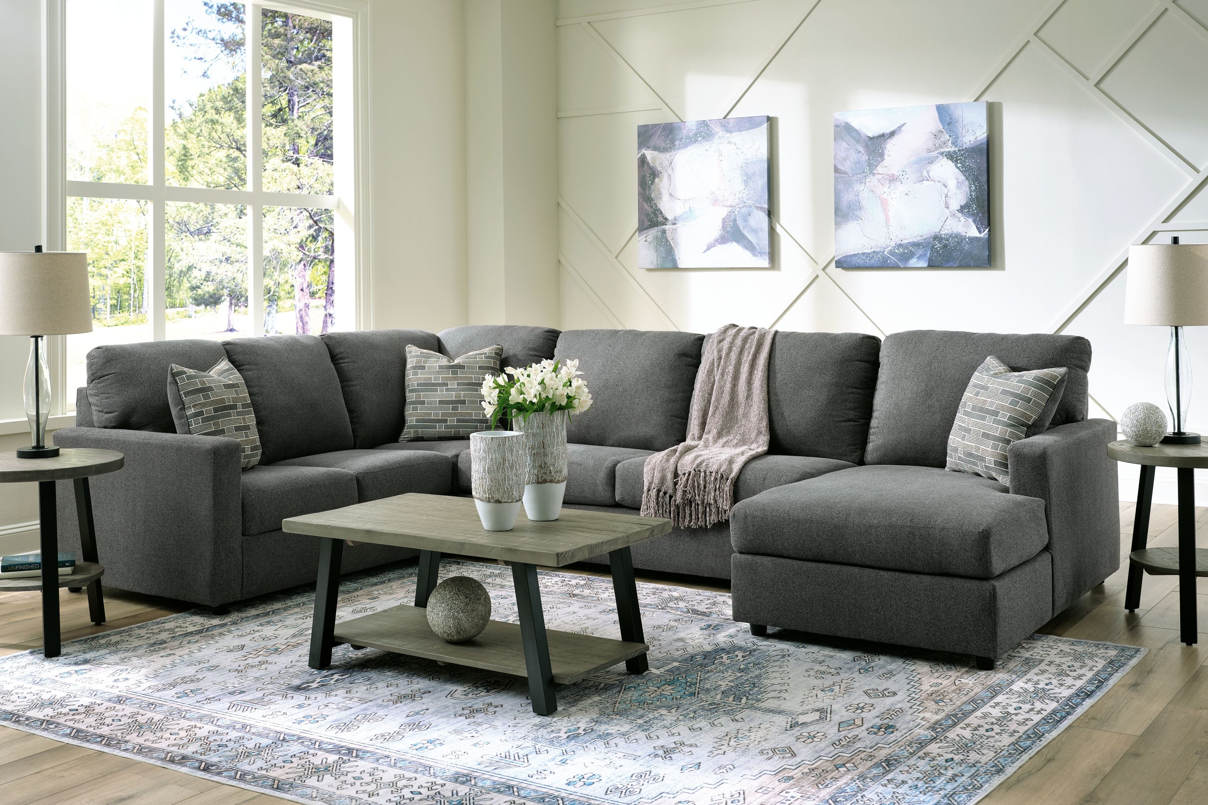 Charcoal sectional sofa with chaise, cushioned arms, and two patterned throw pillows
