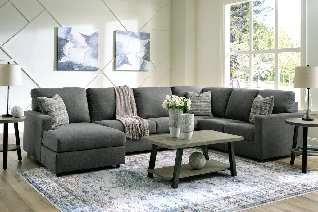 Charcoal sectional sofa with chaise, layered back cushions, and patterned throw pillows