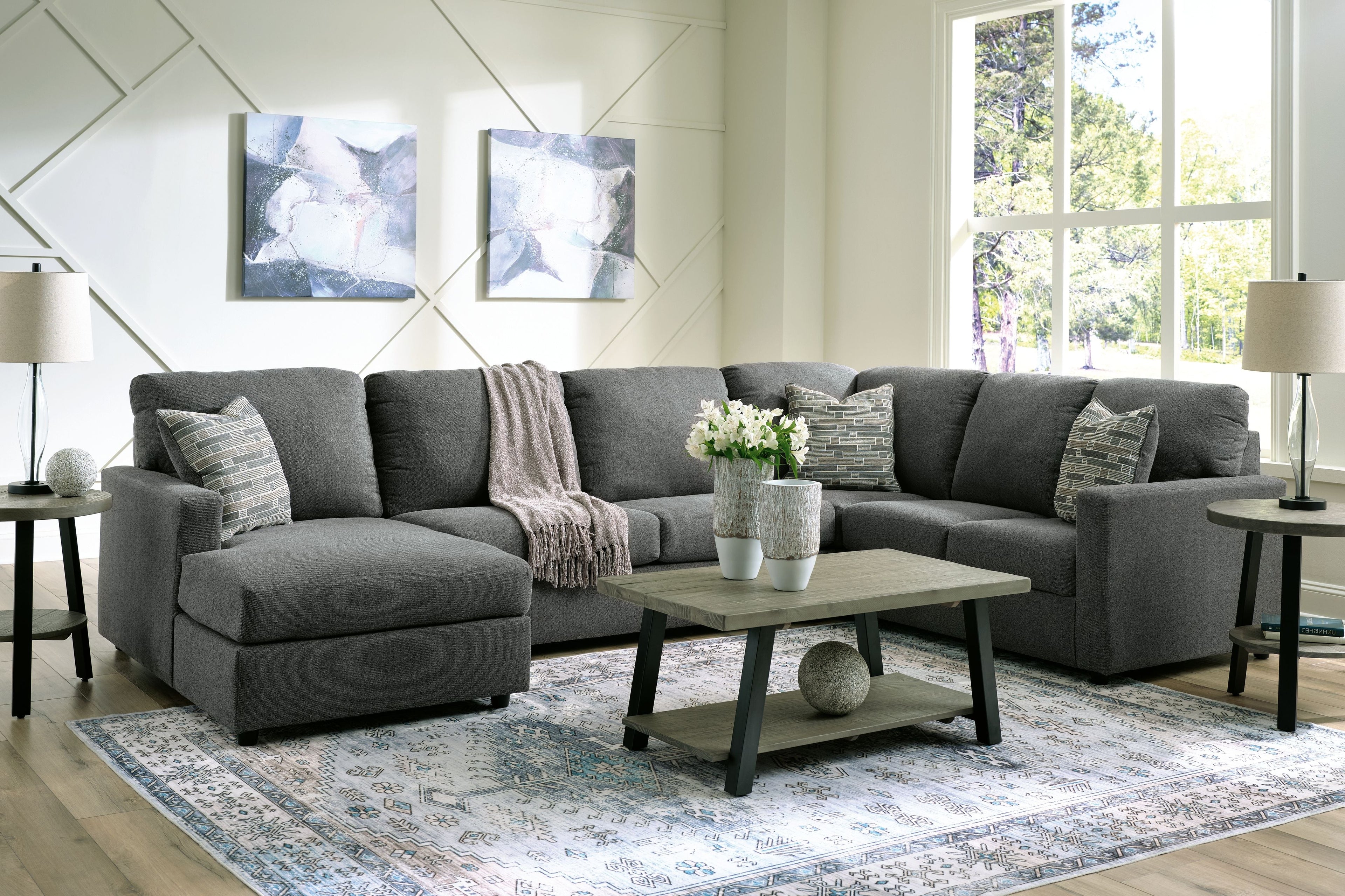 Charcoal sectional sofa with chaise, layered back cushions, and patterned throw pillows