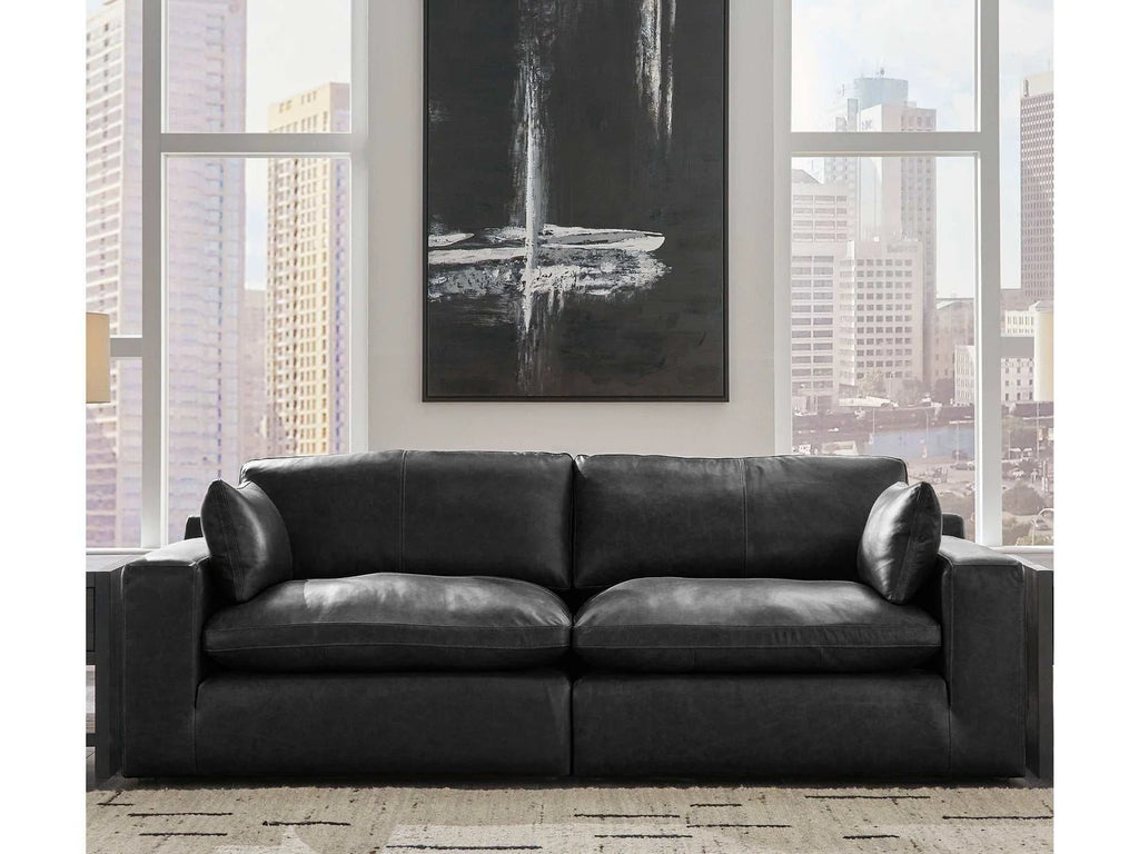 Black sectional sofa with chaise-like end, wide arms, and deep seat cushions