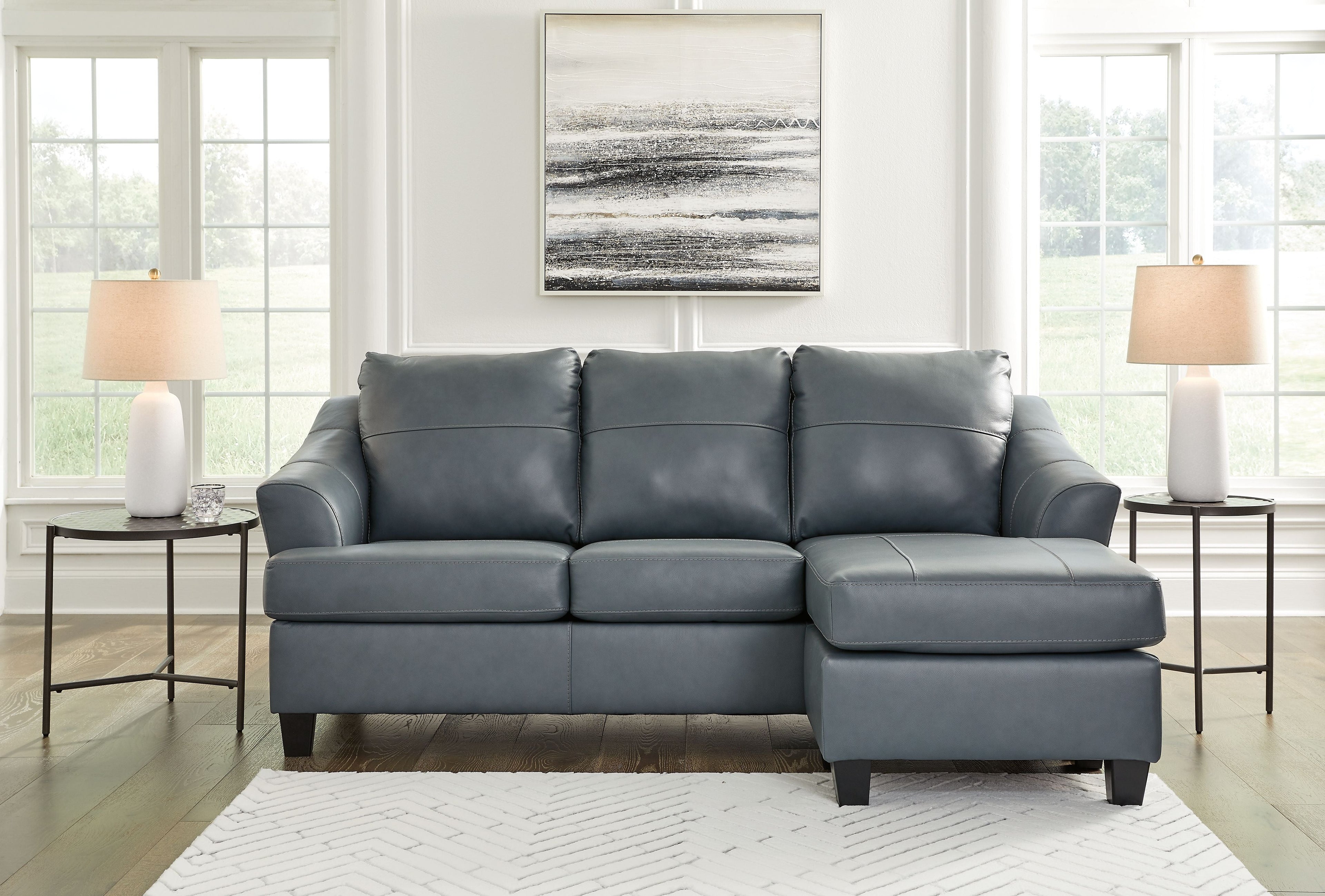 Steel sectional sofa with three seat cushions, tufted back, and corner chaise