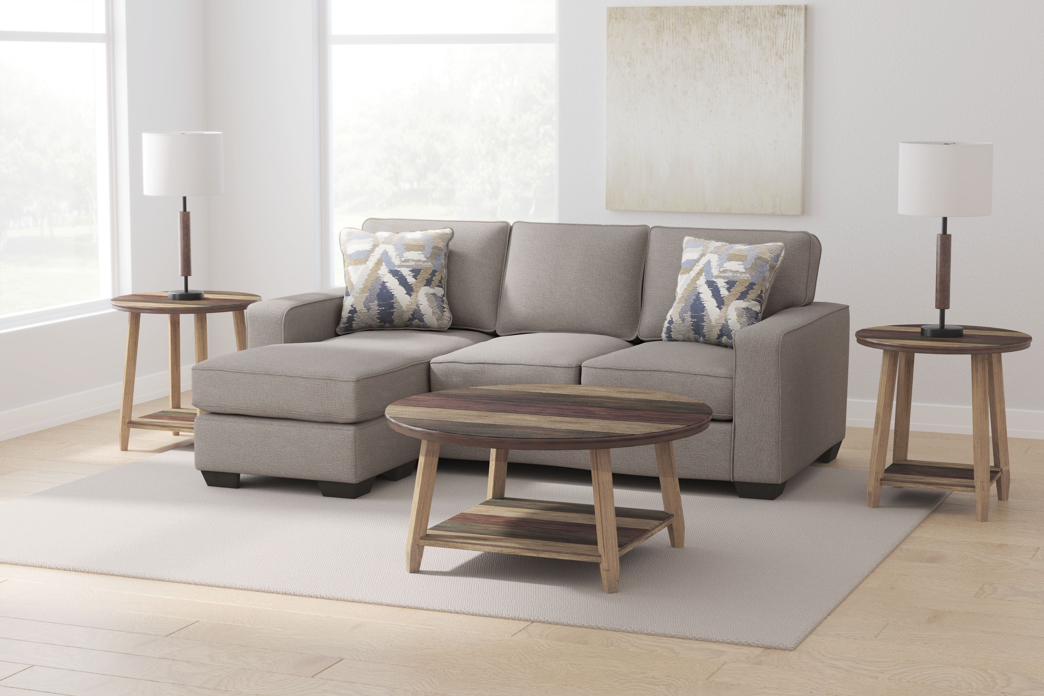 Stone gray sectional sofa with chaise, two patterned pillows, and straight wooden legs