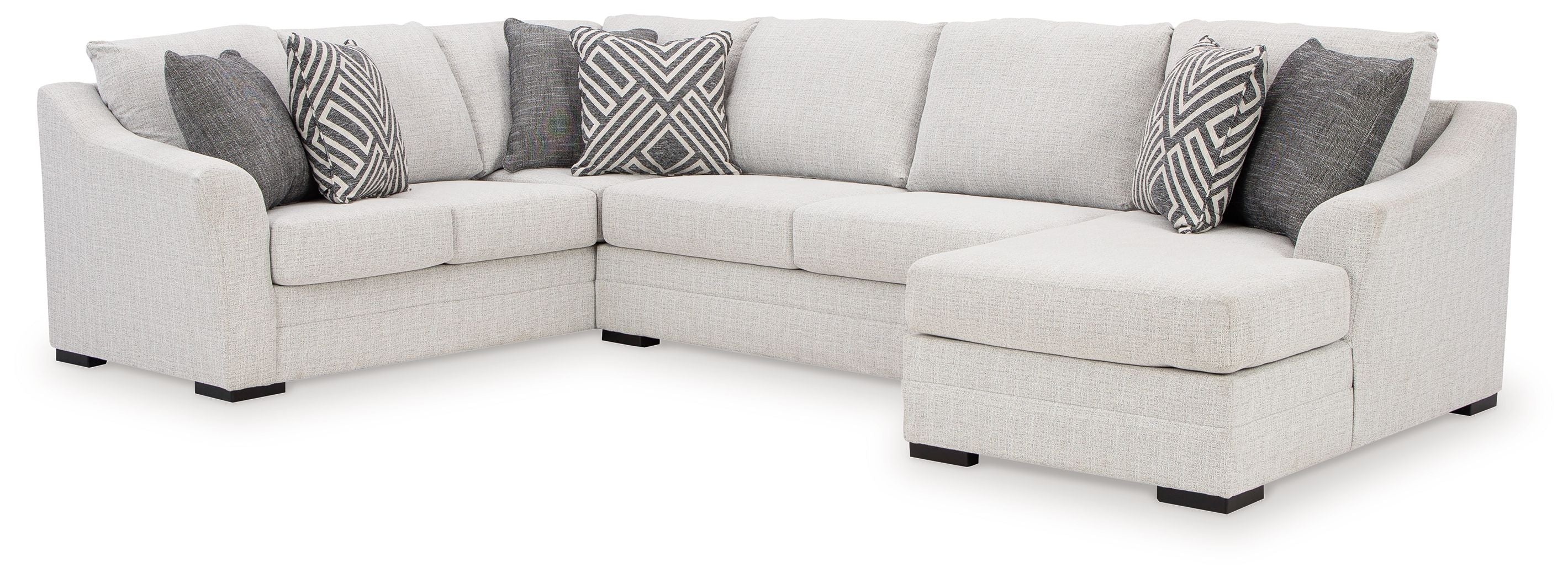 Stone sectional sofa with chaise, light fabric upholstery, black feet, patterned throw pillows