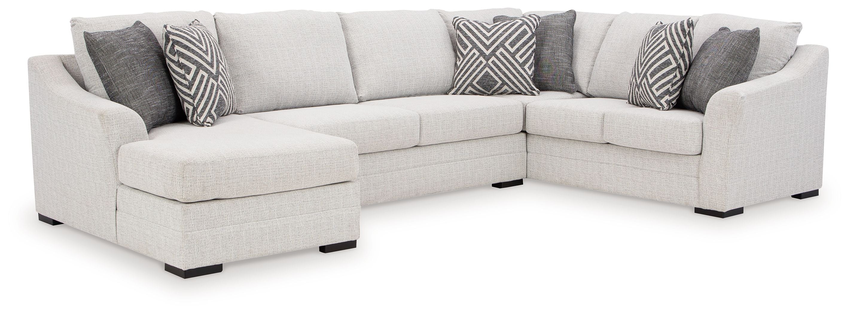 Stone sectional sofa with chaise and armrests, light upholstery, black feet, patterned accent pillows