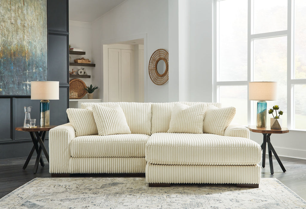 Ivory striped sectional sofa with ottoman-style chaise and square throw pillows