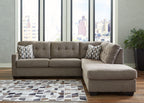 Tufted gray sectional sofa with corner chaise and patterned throw pillows, open chaise cushion
