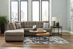 Gray corner sectional sofa with tufted cushions, patterned throw pillows, and chaise seating