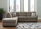 Gray sectional sofa with chaise extension, tufted back and arms, decorative pillows on both ends