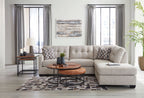 Light gray sectional with chaise, patterned pillows, and neatly arranged cushions