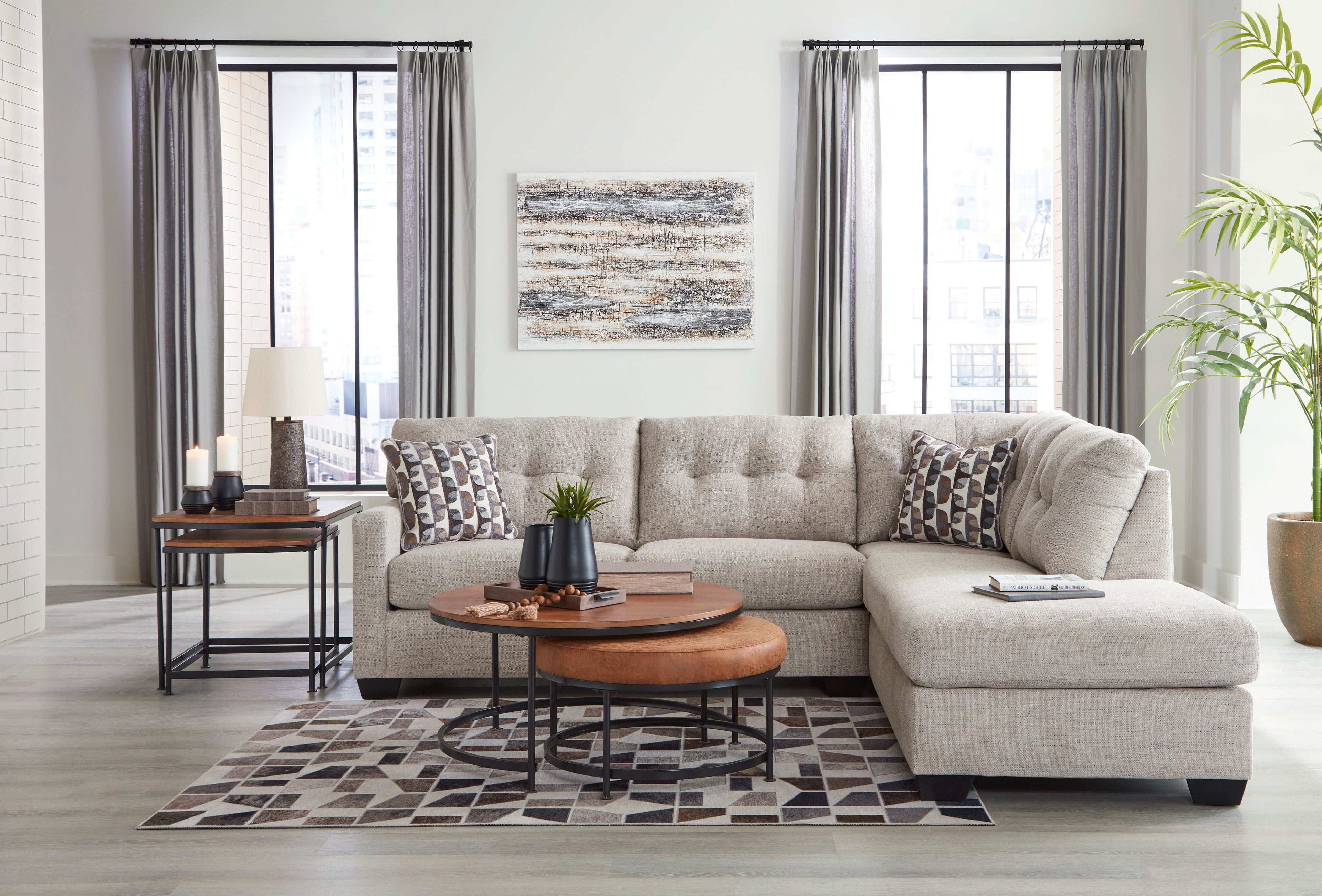 Light gray sectional with chaise, patterned pillows, and neatly arranged cushions
