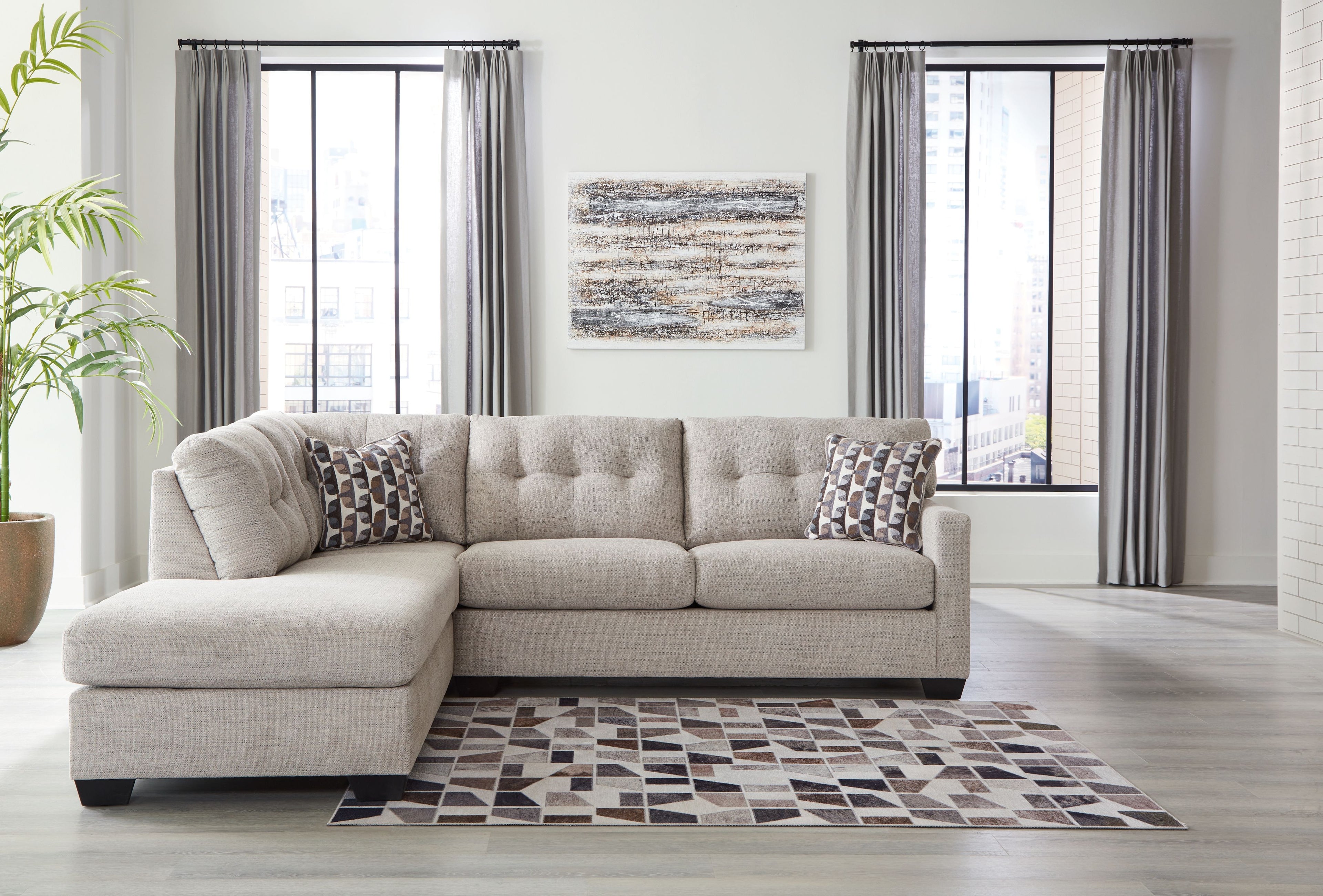 Light gray sectional sofa with chaise and patterned throw pillows