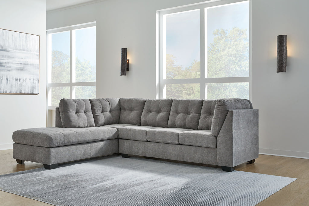Gray sectional sofa with corner chaise, tufted back, and thick seat cushions in living room