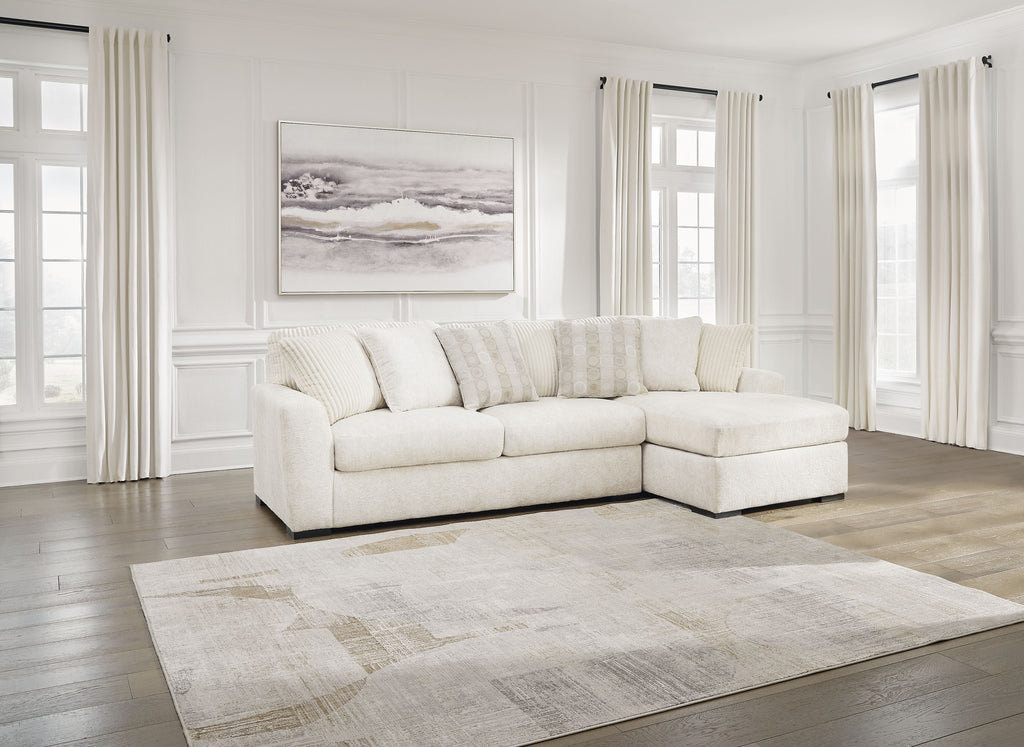 Ivory sectional sofa with corner chaise, low profile arms, and multiple lumbar pillows