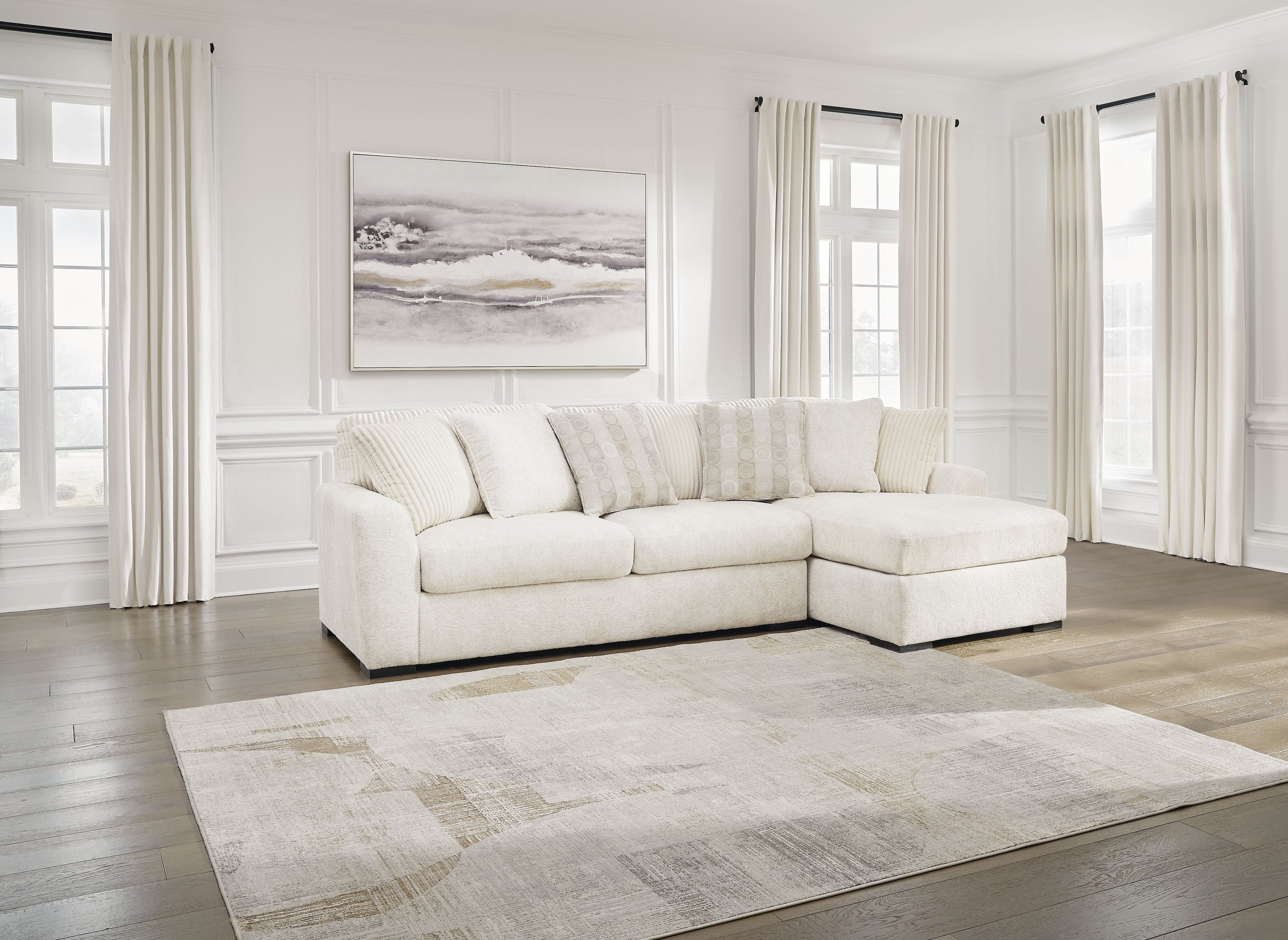 Ivory sectional sofa with corner chaise, low profile arms, and multiple lumbar pillows