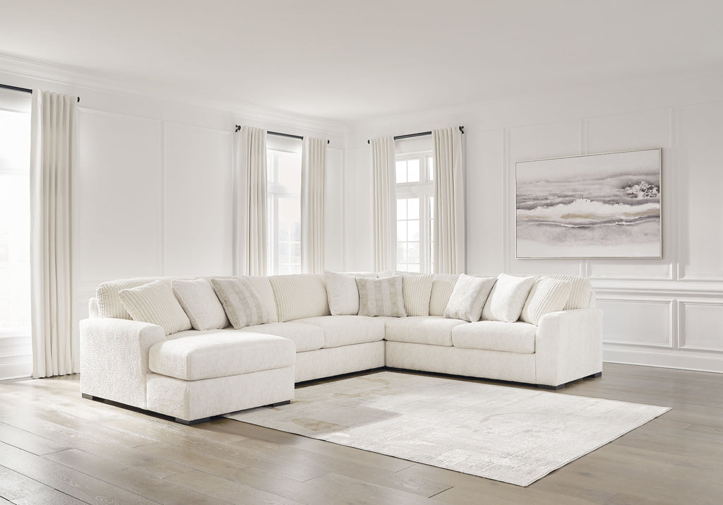 Ivory fabric sectional sofa with chaise arm and tufted seat cushions, corner design